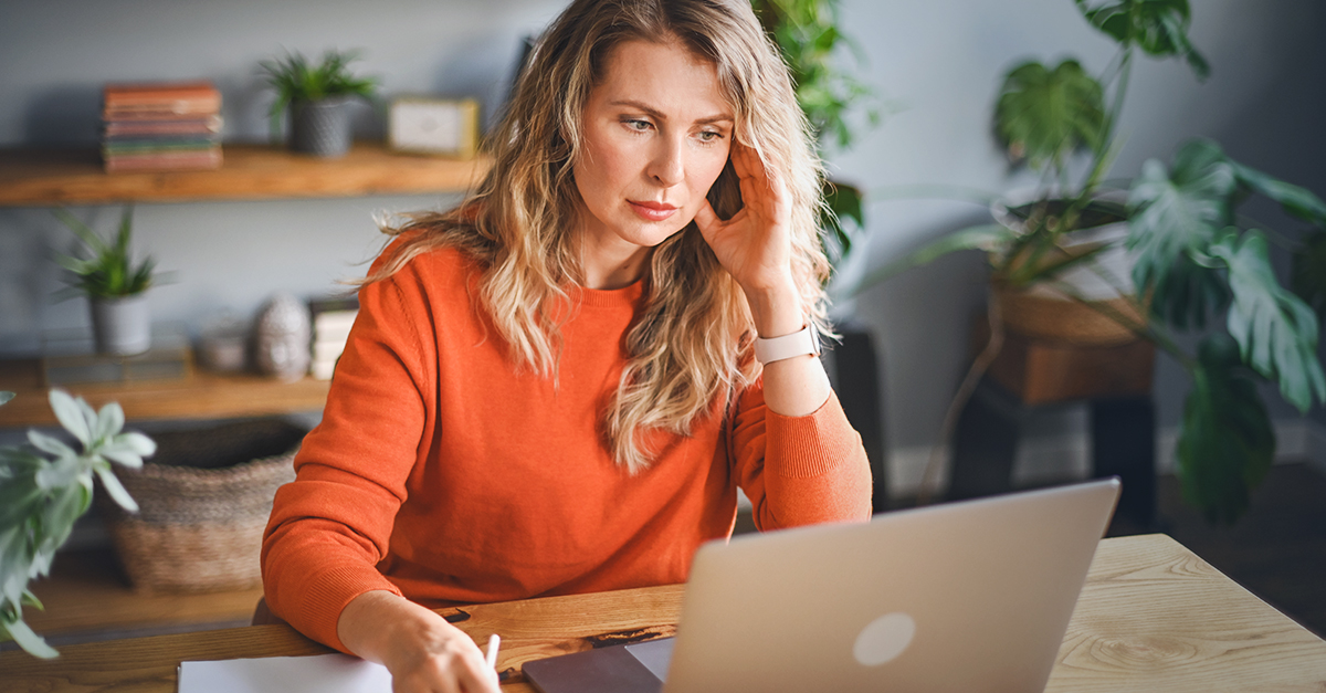 Woman focuses while looking at her laptop