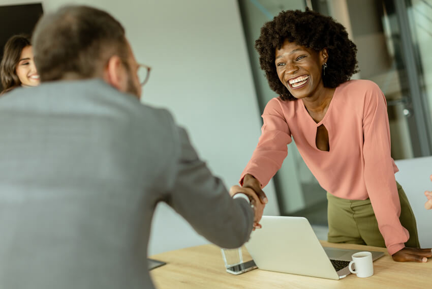Man and woman shaking hands after discussing strategies to enhance talent recruitment.