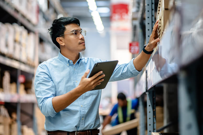 A male supply chain worker checking inventory amidst a staffing shortage.