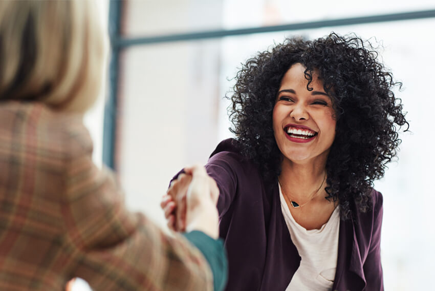 A female job seeker networking during the September Surge to find a new job.