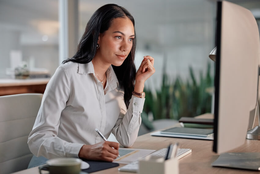 A female job candidate sitting at a desk building a personal brand on her computer.