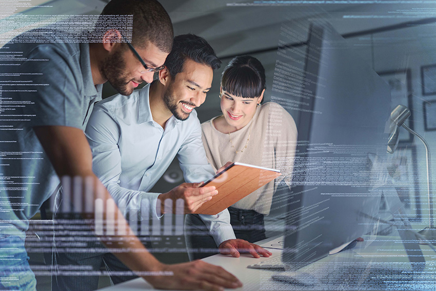 A group of business people gathered around a computer screen