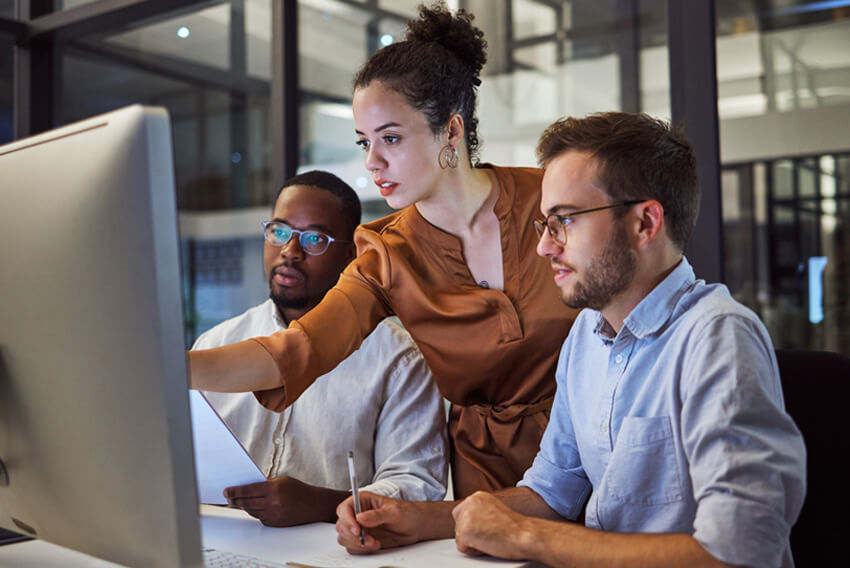 Femme cheffe de projet collaborant avec des hommes cadres supérieurs en comptabilité et finances pour procéder avec succès à la mise en œuvre du système de gestion intégrée Workday.