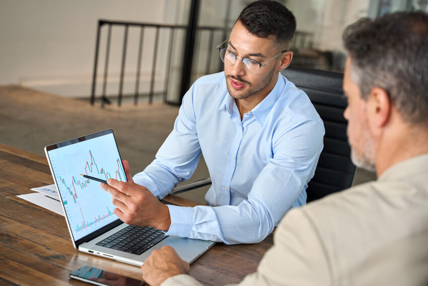 Male coworkers discussing October2024 jobs report looking at September labor market trends from the September hirng surge.